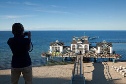 Frau macht ein Foto von der Seebrücke, Sellin, Insel Rügen, Ostsee, Mecklenburg-Vorpommern, Deutschland