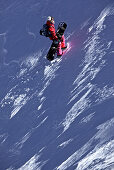 Snowboarderin steigt durch Tiefschnee in den Bergen, Pitztal, Tirol, Österreich