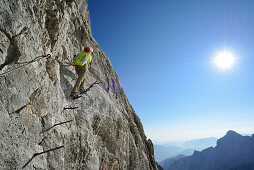 Woman ascending on fixed rope route to Zugspitze, Wetterstein mountain range, Upper Bavaria, Bavaria, Germany