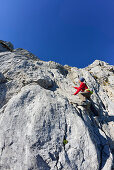 Frau klettert über Felsen zum Hochkalter, Nationalpark Berchtesgaden, Berchtesgadener Alpen, Oberbayern, Bayern, Deutschland