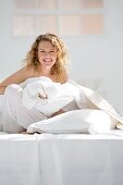 Attractive young woman wrapped in her quilt in bed