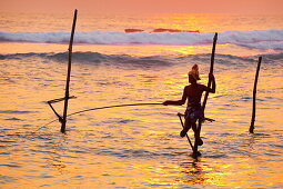 Sri Lanka - fisherman catches fish in a traditional way, Koggala Beach at sunset time, south part of Sri Lanka, Indian Ocean coast, Asia