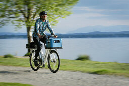 Mann fährt mit einem e-Bike am Starnberger See entlang, Oberbayern, Bayern, Deutschland