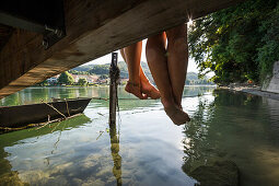 Two young women sitting on a jetty at river Rhine, Rheinfelden, Baden-Wuerttemberg, Germany