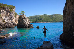 Woman on a diving board, La Grotta Bay, near Paleokastritsa, Corfu island, Ionian islands, Greece