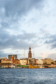 View over river Elbe to Landungsbruecken and church St. Michael in sunset, Hamburg, Germany