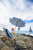 Deck chair and sunshades at coast, Bagni Scogliera, Nervi, Genoa, Liguria, Italia