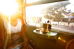 Man looking out of a train window, Jakarta, Java, Indonesia