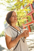 Woman holding a coffee to go, Munich, Bavaria, Germany