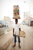 Alison trägt mobilen Kiosk auf dem Kopf, Ganxi, Cotonou, Benin