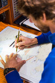 Skipper planing a route on a nautical chart at a sailing boat, Pula, Istria, Croatia