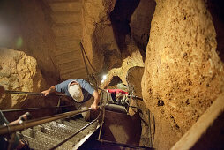 Visitors climbing down in deep cave, Laichinger Tiefenhoehle, Laichingen, Swabian Alp, Baden-Wuerttemberg, Germany