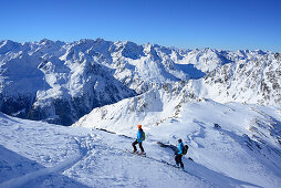Zwei Frauen auf Skitour steigen zur Kuhscheibe auf, Ötztaler Alpen im Hintergrund, Stubaier Alpen, Tirol, Österreich