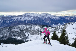 Female back-country skier ascending to Sonntagshorn, Berchtesgaden Alps in background, Chiemgau Alps, Salzburg, Austria