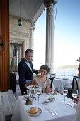 Waiter serving dinner on terrace of a hotel restaurant, Istanbul, Turkey