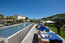 Gäste entspannen auf Sonnenliegen am Pool, Hotel Les Andeols, Saint-Saturnin-les-Apt, Provence, Frankreich