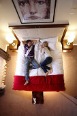 Couple lying on a bed in a hotel suite, Adelboden, Canton of Bern, Switzerland