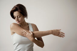 Mature woman stretching arm