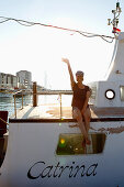 Woman sitting on yacht, waving