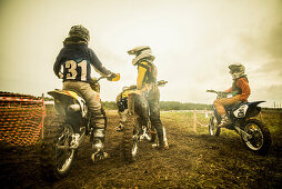 Young man and boys on motorcycles at motocross
