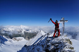 Bergsteiger am vereisten Gipfelkreuz des Nadelhorn (4327 m), Wallis, Schweiz