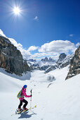 Female back-country skier ascending to Hochebenkofel, Sexten Dolomites, South Tyrol, Italy