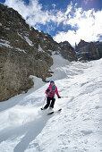 Female back-country skier downhill skiing through Val Setus, Sella Group, Dolomites, South Tyrol, Italy