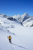 Female back-country skier ascending to Piz Buin, Silvretta Range, Lower Engadin, Engadin, Canton of Graubuenden, Switzerland