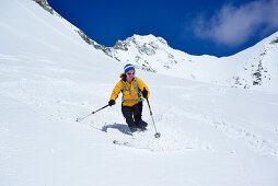Female back-country skier downhill skiing from Grosser Moeseler, Zillertal Alps, South Tyrol, Italy