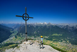 Frau am Gipfel des Tschirgant, Inntal, Lechtaler Alpen, Imst und Tarrenz im Hintergrund, Mieminger Gebirge, Tirol, Österreich