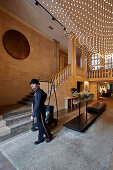 Page boy Fabian Enrique Flores Islas welcoming guests in the lobby of Das Stue Hotel, Drakestrasse 1, Tiergarten, Berlin, Germany