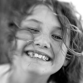 Cheeky young girl smiling into the camera (black and white photo using Lensbaby technique), Borden, Western Australia, Australia