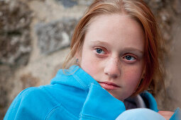 Red haired teenage girl with blue sweater and blue eyes looking dreamy, Clonmacnoise, County Offaly, Ireland, Europe