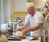 Baker Erwin Oehl making bread in his bakery, Frankenau, Hesse, Germany, Europe