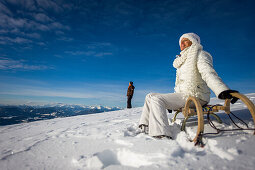 Paar mit Schlitten in Schnee, Mühlen, Steiermark, Österreich