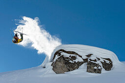 Skifahrer macht massiven Backflip über Kliff und zieht Schweif hinterher, Hochfügen, Zillertal, Österreich