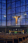 Jesus on the cross in front of the blue coloured glass facade in Emperor Wilhelm memorial church on Kurfuerstendamm, Berlin, Germany