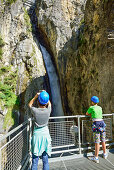 Two visitors looing at Loetz waterfall, Zammer Lochputz, Zams, Tyrol, Austria