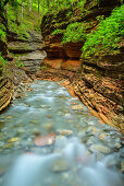 Stream flowing through red canyon, Salzkammergut, Salzburg, Austria