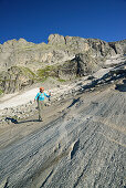 Woman hiking on rock slab, Sentiero Roma, Bergell range, Lombardy, Italy