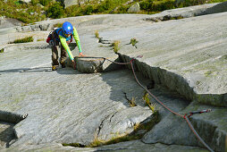 Frau klettert an Granitplatten, Räterichsboden, Grimselpass, Berner Oberland, Schweiz