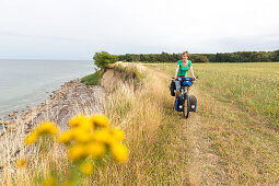 Fahrradfahrerin fährt an der Ostsee entlang, Naesgaard, Falster, Dänemark