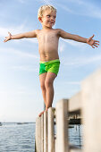 Junge (4 Jahre) balanciert auf einem Bootssteg, Gedser, Falster, Dänemark