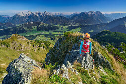 Frau steigt über Bergrücken auf, Loferer Steinberge im Hintergrund, Klettersteig Henne, Henne, Kitzbüheler Alpen, Tirol, Österreich