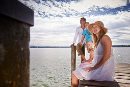 Family on a jetty at lake Starnberg, Upper Bavaria, Bavaria, Germany