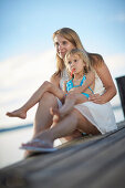 Mother and daughter on a jetty at lake Starnberg, Upper Bavaria, Bavaria, Germany