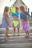 Three girls with dip nets on jetty at Starnberger See, Oberbayern, Bayern, Deutschland