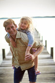 Father and daughter on a jetty at lake Starnberg, Upper Bavaria, Bavaria, Germany