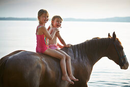 Zwei Mädchen auf einem Pferd am Starnberger See, Oberbayern, Bayern, Deutschland