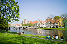 Lawn on river Obertrave with view to historic city, Lubeck, Schleswig-Holstein, Germany